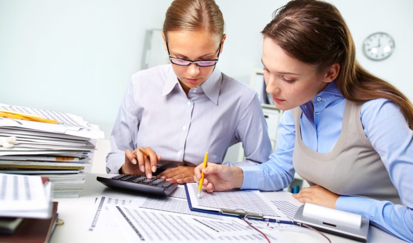 Concentrated business women reviewing accounting report