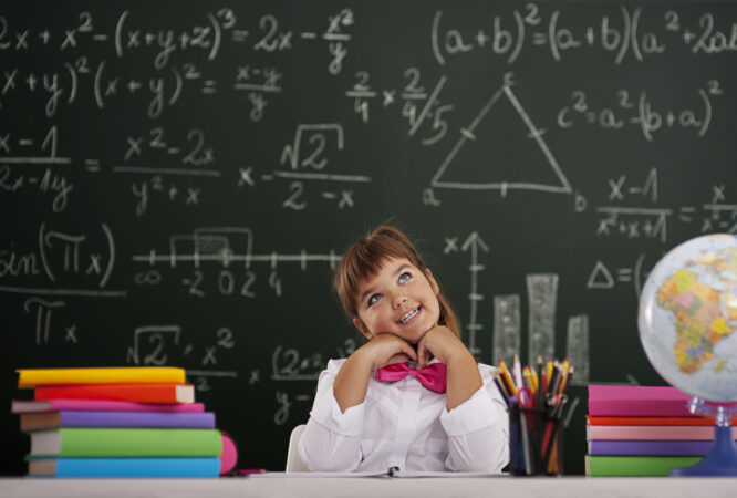 Happy girl sitting and dreaming in classroom