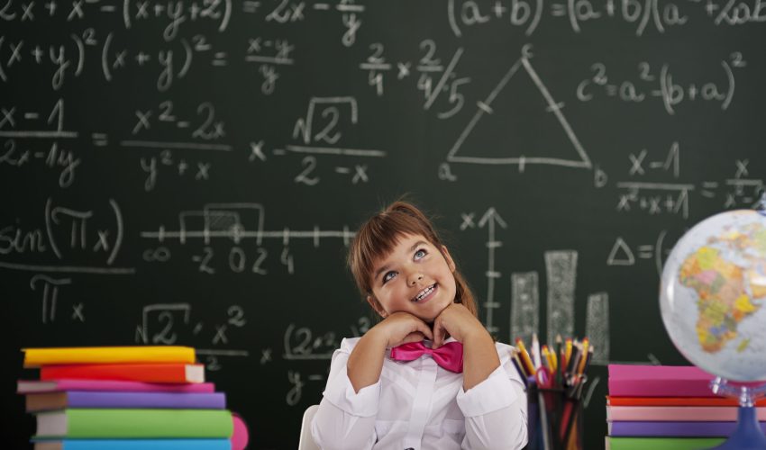 Happy girl sitting and dreaming in classroom
