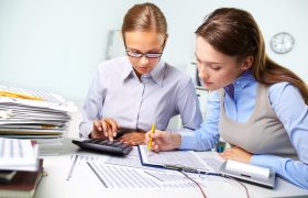 Concentrated business women reviewing accounting report