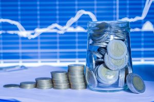 Coins in bottles with trading graph. financial investment concept use for background.