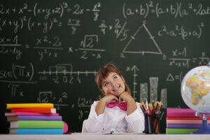 Happy girl sitting and dreaming in classroom