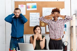 Colleagues closing mouth, eyes and ears with hands in office.
