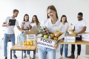 smiley-female-volunteer-holding-food-donations-box